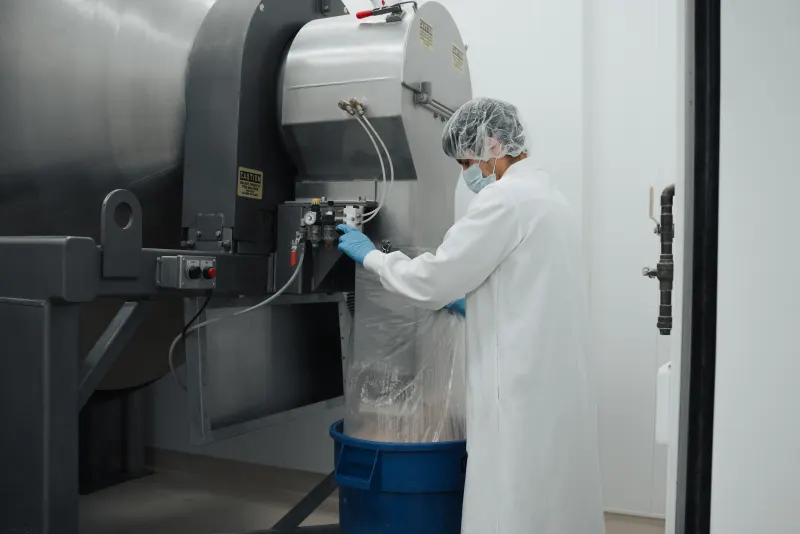 Adept operator drawing finished powder from a stainless blending tank
